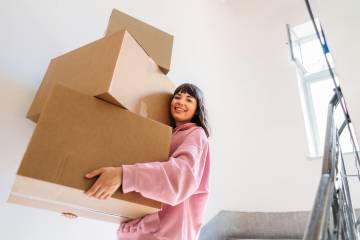 A person carrying boxes during a move.