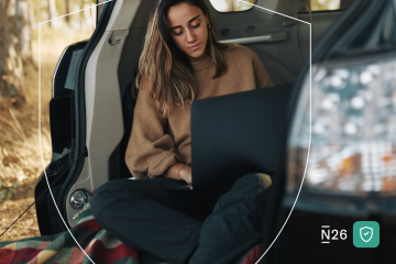 Woman works on laptop from car.