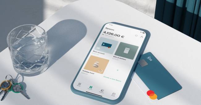 N26 Spaces on phone screen, N26 You card, keys and a glass on a table.