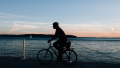 Ein Mann, der bei Sonnenuntergang Fahrrad fährt.