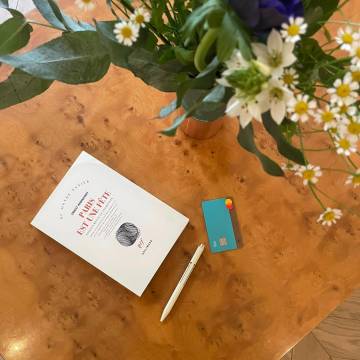 A book, a bunch of flowers and a N26 card.