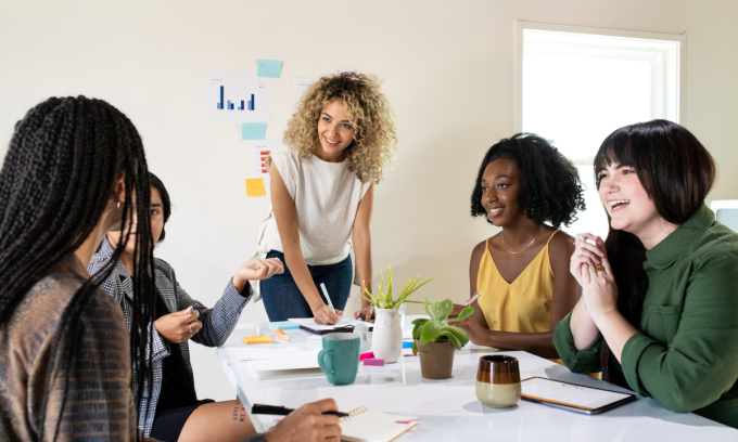 Five women sitting on a meeting room.