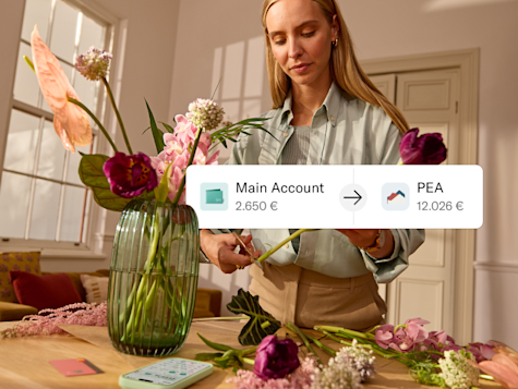 A woman arranges flowers while a graphic shows a transfer from her main account to a PEA account.
