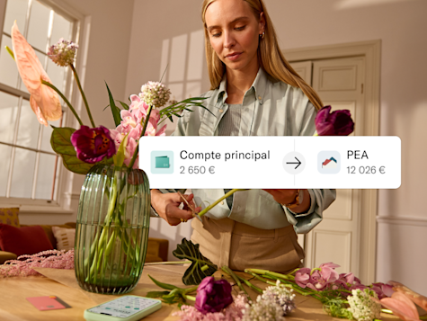 Une femme arrange des fleurs pendant qu'un graphique montre un transfert de son compte principal vers un compte PEA.
