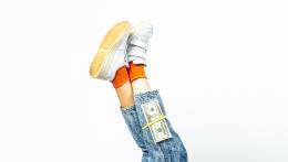 Stack of money on legs wearing jeans.