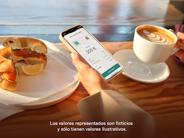 Una mano sostiene un smartphone que muestra la pantalla de inversión N26 con acciones populares como Amazon y Apple.