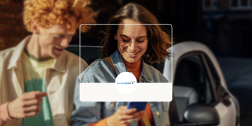 Woman and man booking a car with a Share Now car behind.