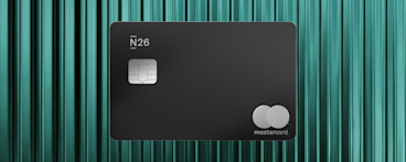 A matte black N26 Metal card with a silver chip and a minimalist silver Mastercard logo set against a textured teal background.