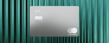 A matte black N26 Metal card with a silver chip and a minimalist silver Mastercard logo set against a textured teal background.