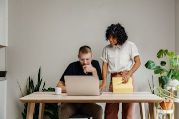 femme regarde écran collègue.