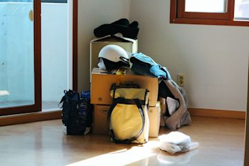 scatolini, zaini e vestiti in un angolo della casa.