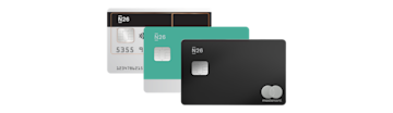 Una fila de tres tarjetas de débito N26 Mastercard en plateado, verde azulado y negro está extendida en abanico sobre un fondo gris.