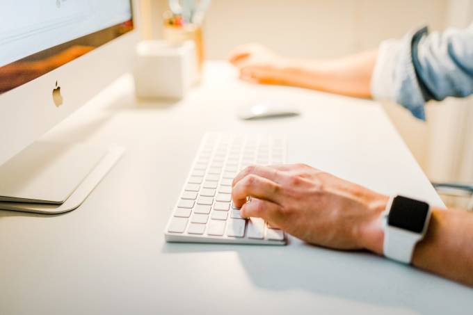 Man working on his computer writing on the keyboard.