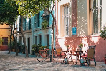 Mesas fuera de edificios coloridos.