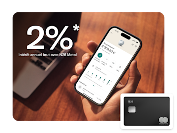 Un smartphone affiche le taux d'intérêt d'épargne et le solde de l'application N26 à côté d'une carte N26 Metal noire.