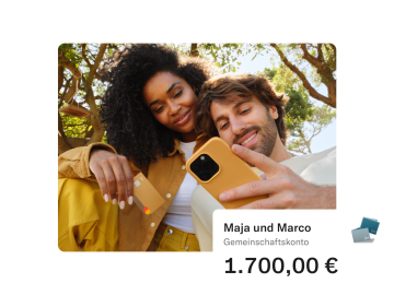 Maya und Marco sitzen in einem Park. Maya hält ihre N26-Karte in der Hand und Marco blickt auf sein Handy. Im Vordergrund erscheint ein Popup mit dem Geldbetrag auf dem gemeinsamen Konto.