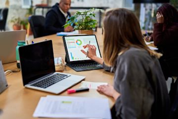 Femme dans un ordinateur travaillant sur une recherche financière.