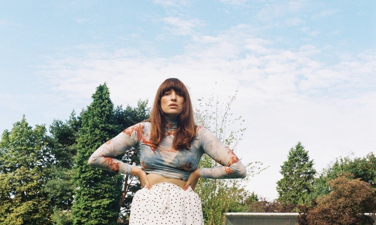 Una escritora freelance selante de un fondo con cielo azul.