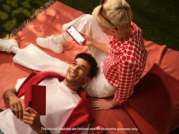 Woman sitting watching Crypto on the N26 app with a man lying next to her.