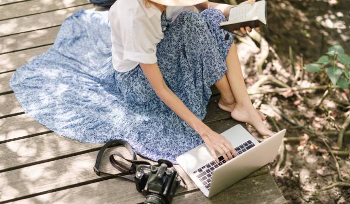 Freelance Fotografin mit einer Kamera und einem Laptop.