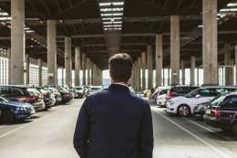 l'homme dans un parking avec plusieurs voitures.