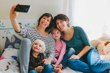 LGBTQIA+ couple taking a family photo.