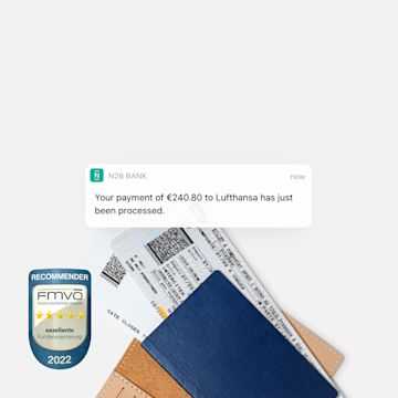 N26 You Instant Push Notification about payment to an airline with two flight tickets in the background.