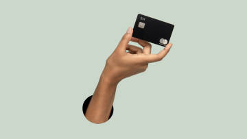 Hand holding the N26 metal Mastercard.