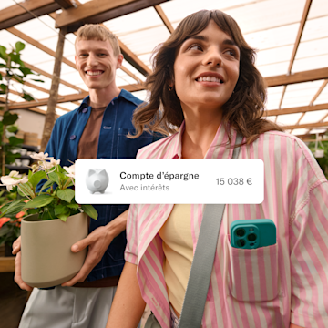 Un homme et une femme dans une serre tiennent une plante en pot, avec une carte superposée affichant un solde d'épargne.
