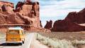 Gelber Volkswagen Minibus, der durch eine kalifornische Wüste fährt.