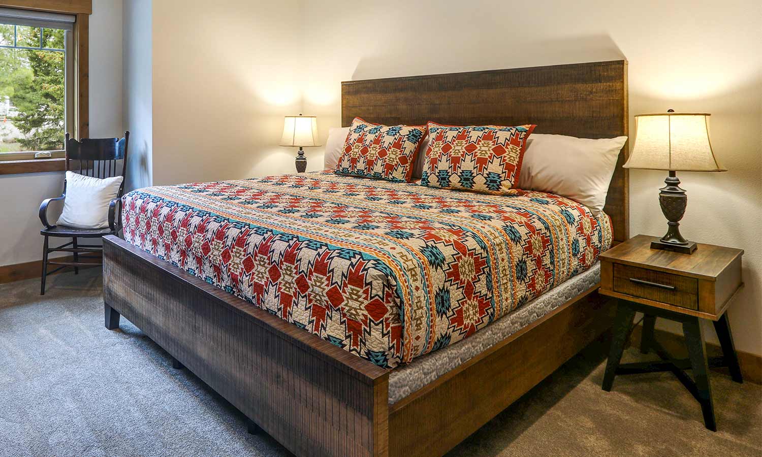 Una cama de paneles con altos rieles de madera en la cabecera y los pies con lados abiertos.