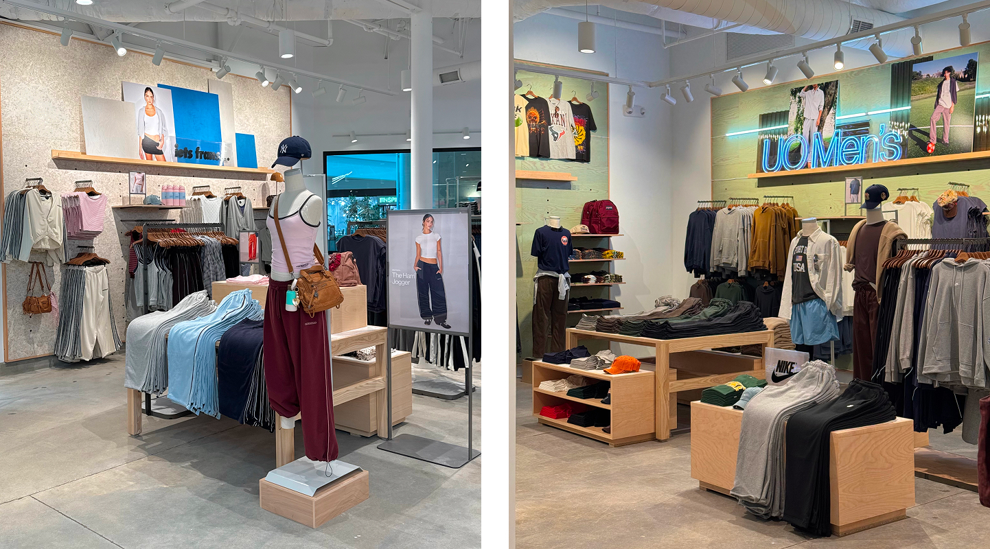 Modern retail clothing store interior with organized displays of casual apparel, wooden fixtures, track lighting, and promotional signage.
