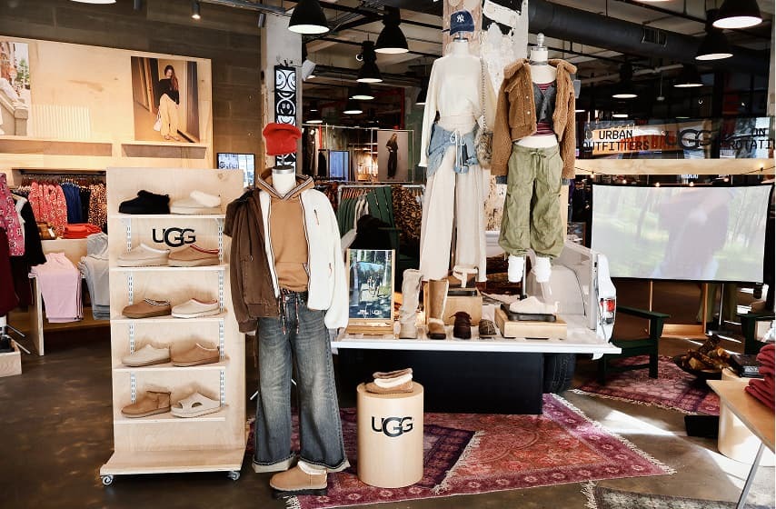 UGG retail store display featuring mannequins in casual wear with boots, shelves of footwear, and Urban Outfitters signage.