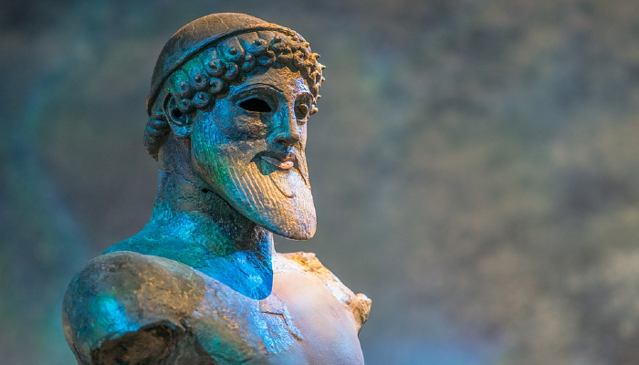 Colour photo of a statue of Poseidon the god of the sea in Greek mythology, showing the head and shoulders.