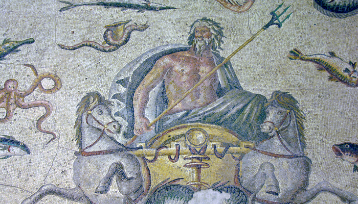 Colour photo of details of a mosaic at the Gaziantep Archaeological Museum. It shows Poseidon holding a trident. He is in a chariot pulled by horses.