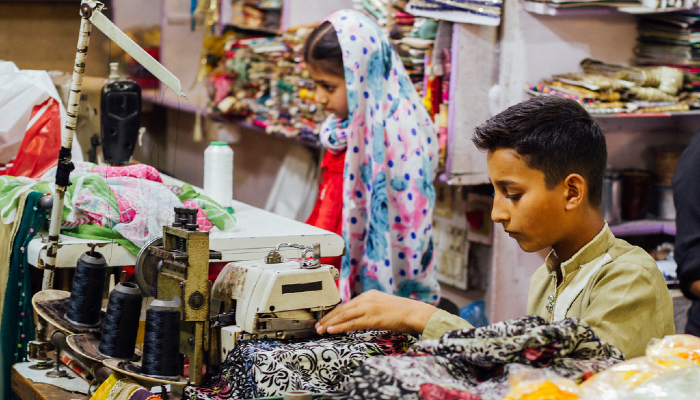 Image: Young Boy Seamstress, Faisalabad Pakistan (https://www.flickr.com/photos/adamcohn/51091197442/) by Adam Cohn on Flickr.
