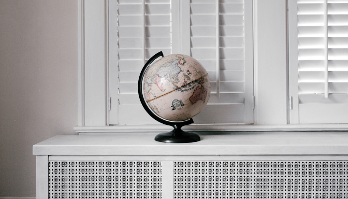 Colour photo of a globe of the world (Earth) on a table. The globe shows the equator and different countries.