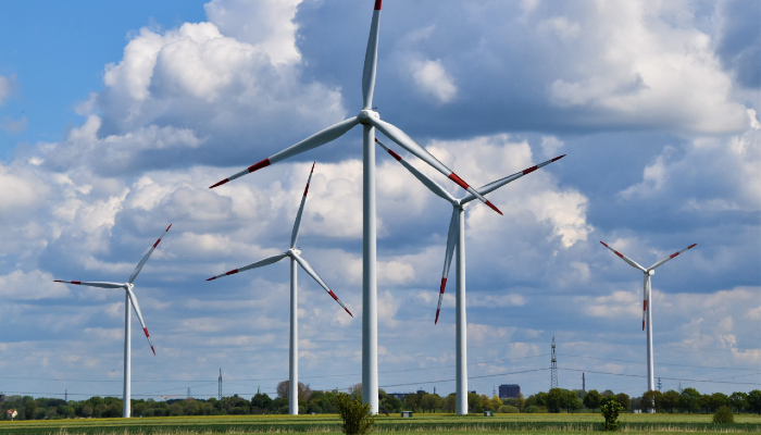 Colour photo of 5 wind turbines on a wind farm in Schleswig- Holstein, Germany.
