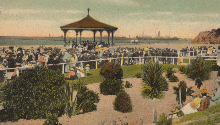 1914-1915 Postcard illustration showing Caroline Bay, Timaru. There is a band playing in the rotunda with a crowd watching.