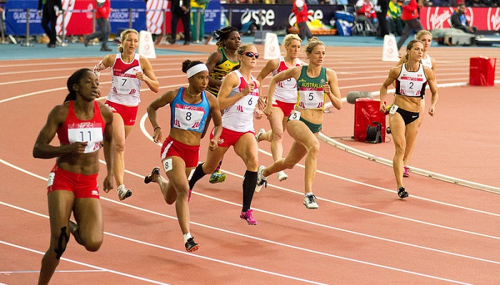 Colour photo of women athletes running in a track and field event at the 2014 Commonwealth Games. They are from different countries.