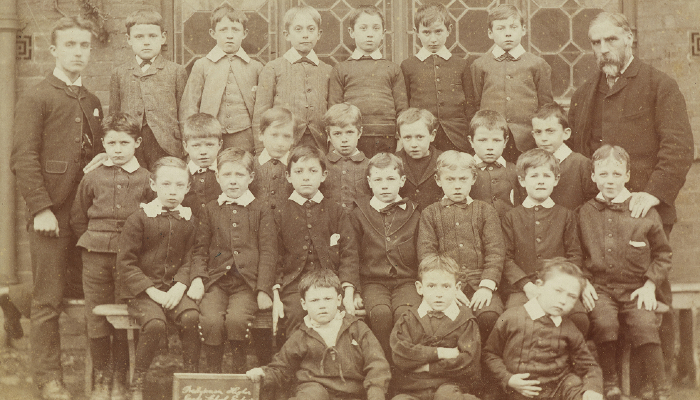 Image: School portrait of a class of boys & teachers (https://www.digitalnz.org/records/37971129?search%5Bi%5D%5Busage%5D=Use+commercially&search%5Btab%5D=Images&search%5Btext%5D=Victorian+children&search%5Bview%5D=gallery) by [unknown]. Collection: Te Papa (modified from original).