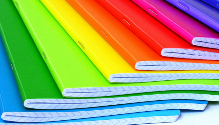 Photo of a pile of brightly coloured notebooks. 