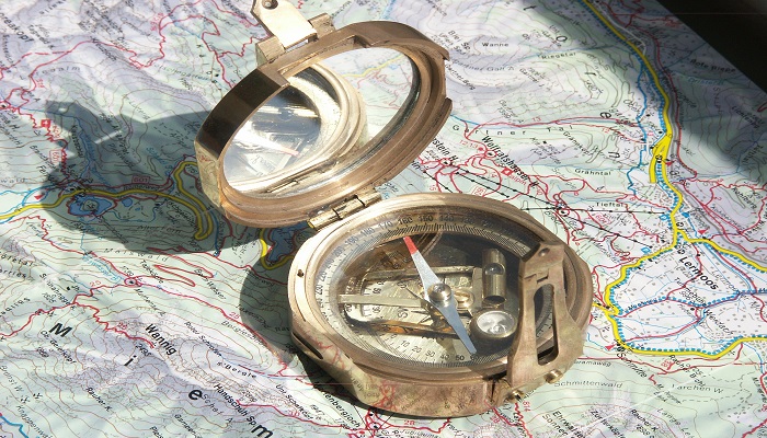 Colour photo of a geological compass sitting open on a map.