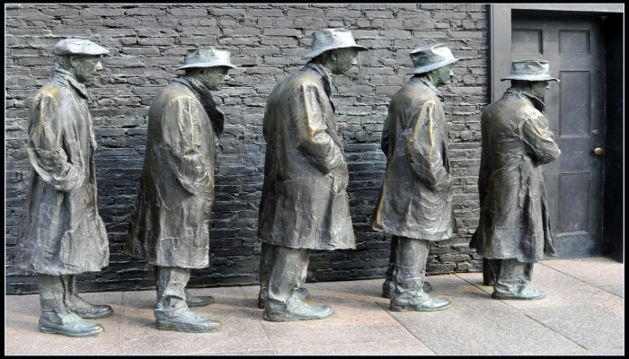 Colour photo from a Great Depression memorial — showing statues of 5 men waiting in line for food.