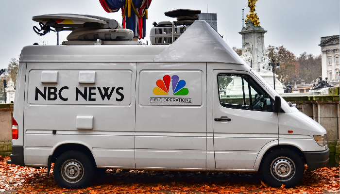 Colour photo of a white NBC News van in St James's Park, London. You can see the Victoria Memorial in the background.