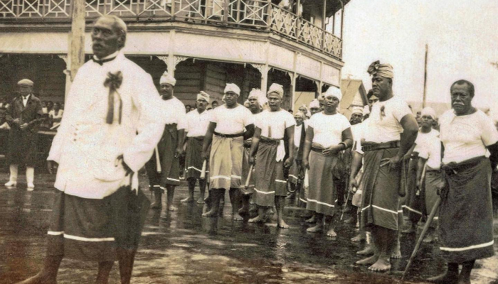 Black and White photo of a Mau movement parade outside the Apia Couthouse in 1929. 