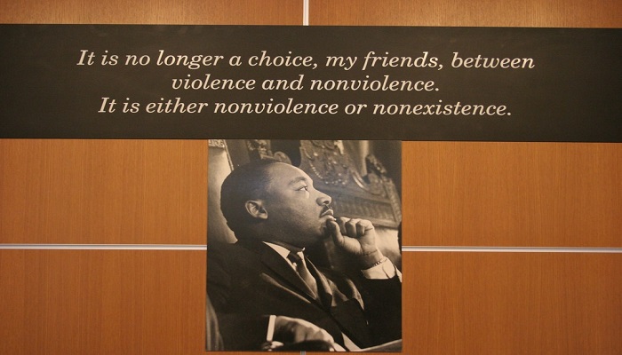Photo of Martin Luther King Jr on display with his quote 'It is no longer a choice, my friends, between violence and non-violence. It is either non-violence or non-existence.'