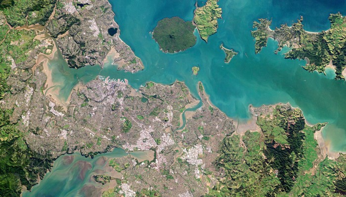 Aerial view of Auckland taken from a satellite. Rangitoto, Motutapu, and Waiheke Islands are along the top.