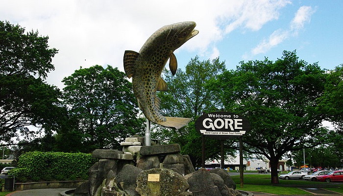 Photo of the Brown Trout Statue in Gore. The sign says 'Welcome to Gore: World Capital of Brown Trout Fishing.' 