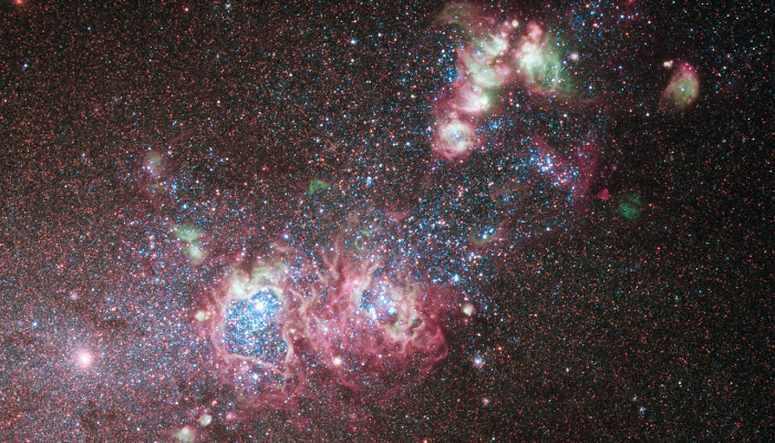 Colour photo of dwarf galaxy NGC 4214 with stars and gas clouds.